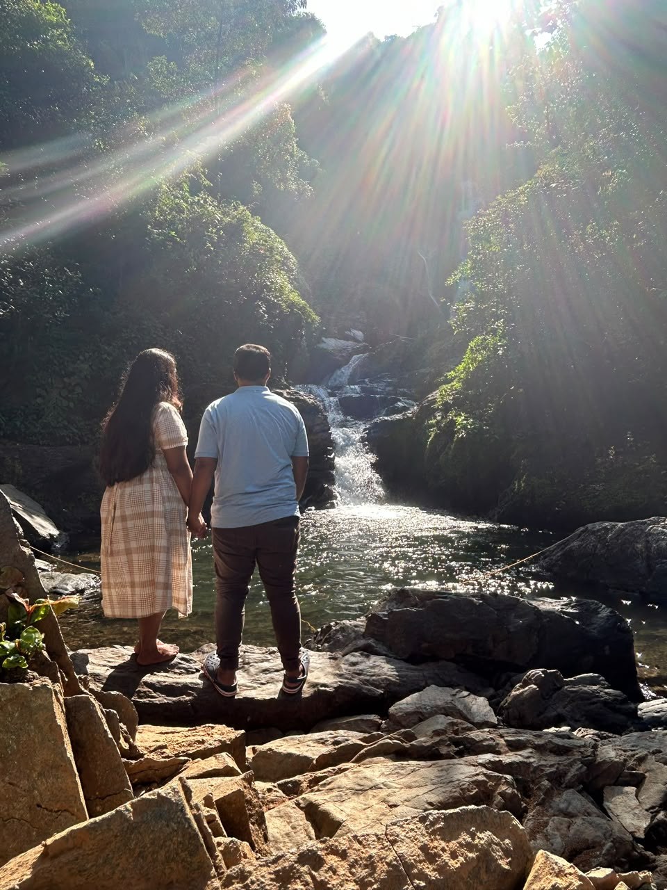 Pradeep and Ananya at a sunlit waterfall
